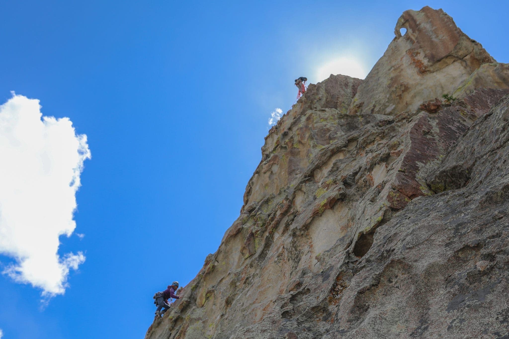 Climbers reaching top of mountain in city of rocks