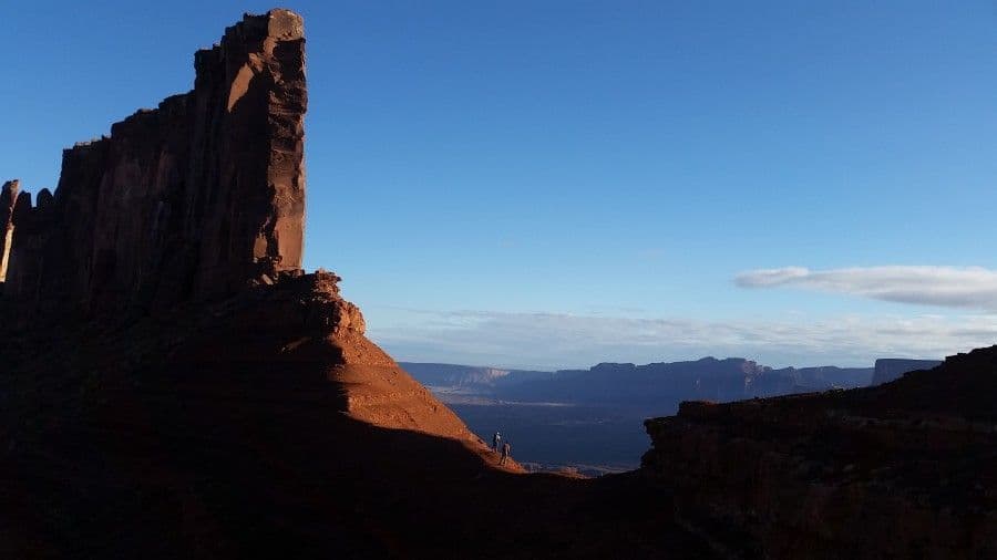People in between large towers in Moab Utah