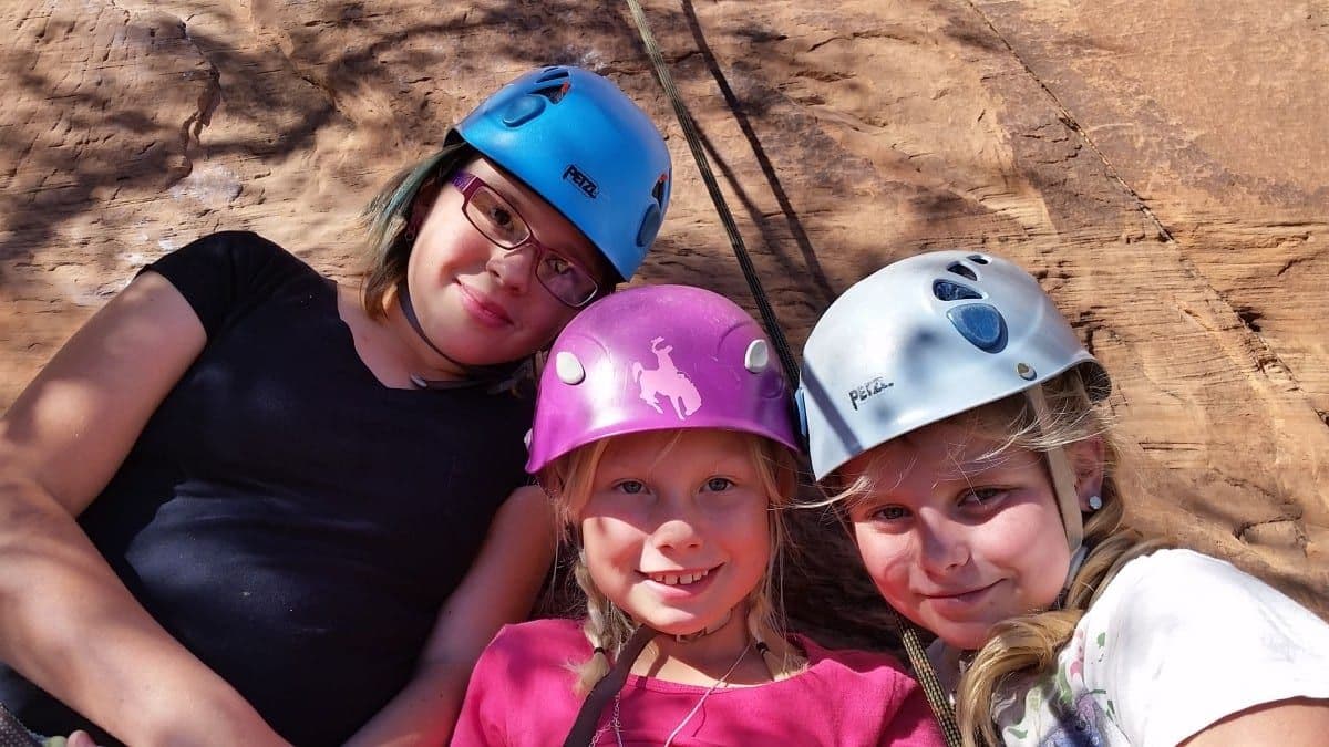 3 kids doing rock climbing 