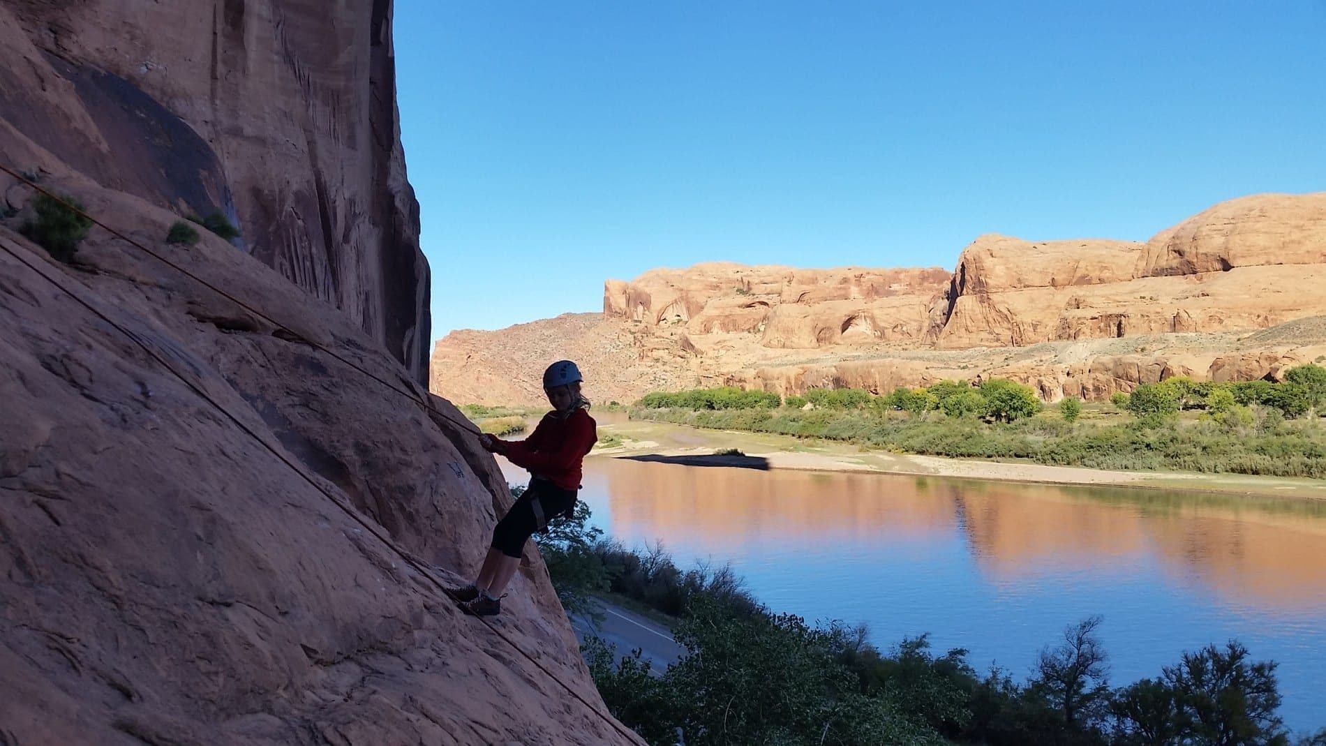 Woman scaling the side of a canyon 
