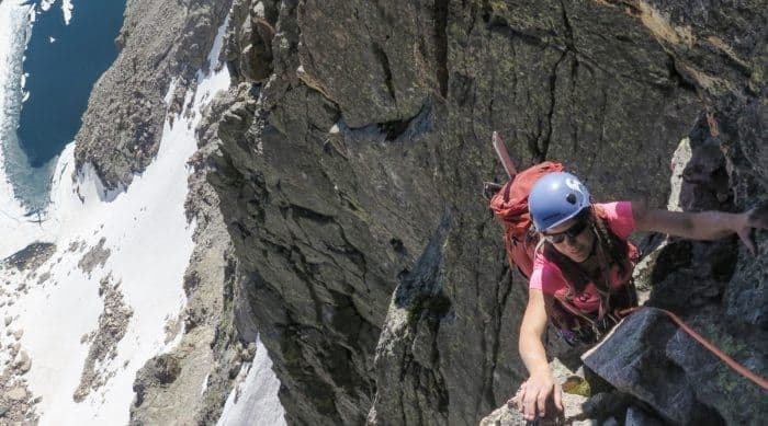Person climbing side of longs peak