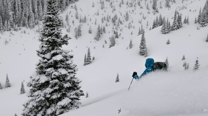 Person skiing down powder in avalanche course 