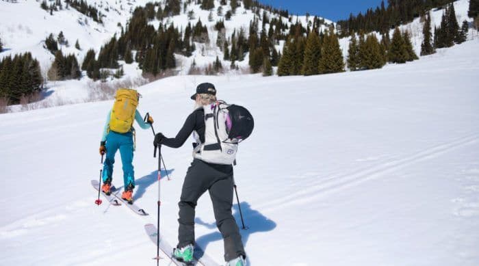 Skiers hike up a mountain
