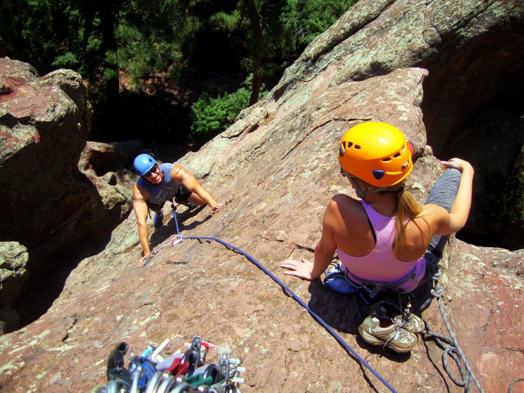 Pair rock climbing on mountain side 