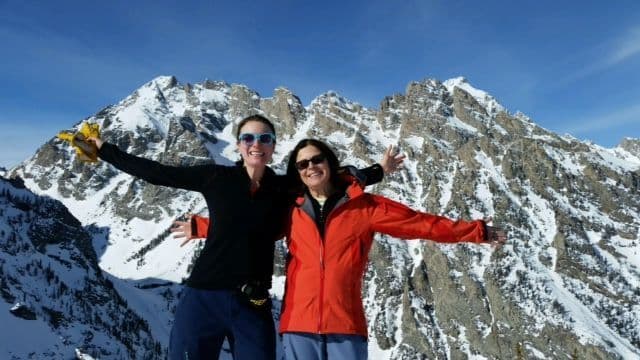 2 women posing on top of mountains