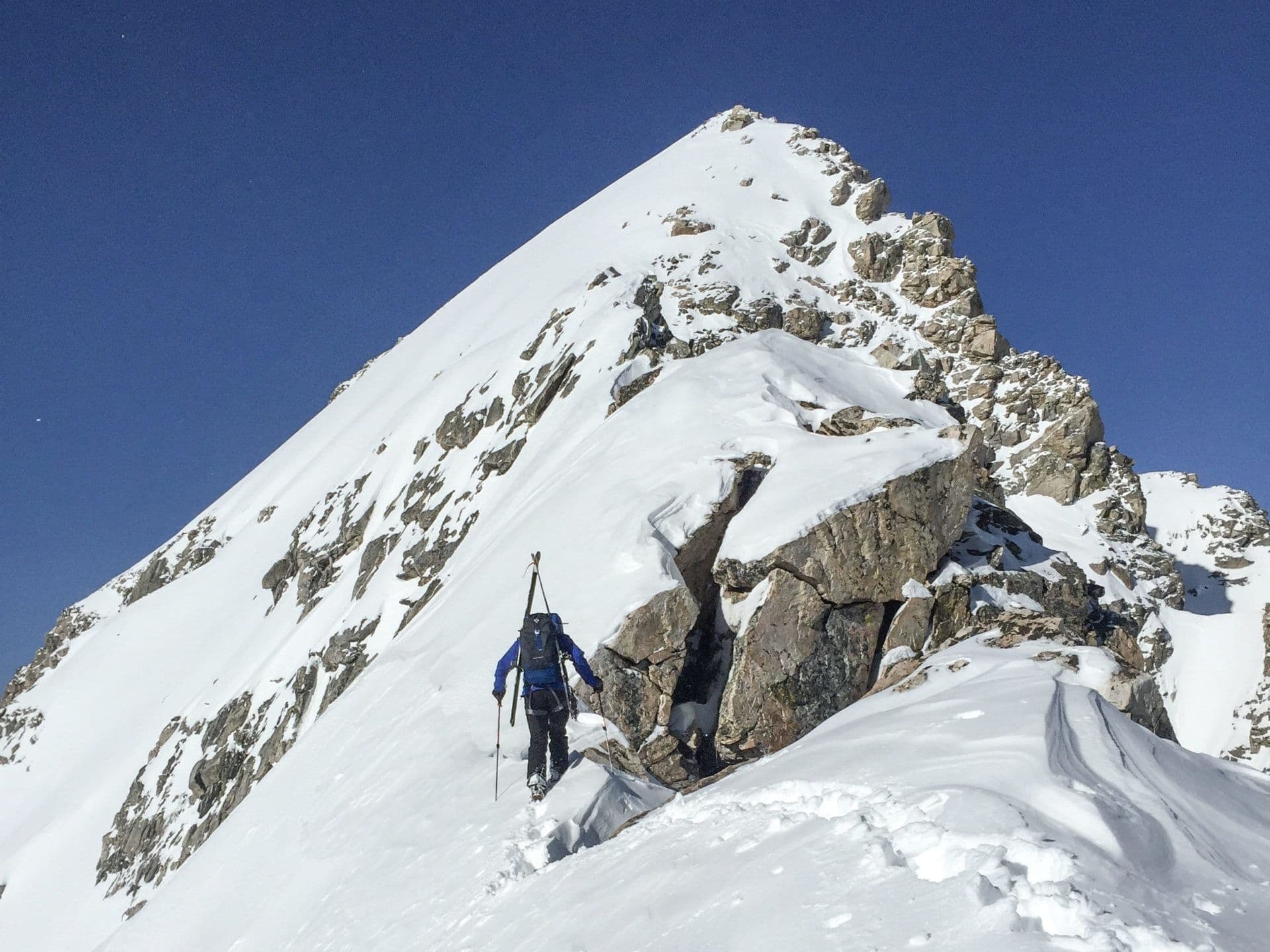 Skier climbing to the top of mountain in Teton national park
