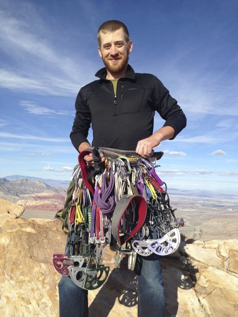 Climber holding trad climbing gear at Red Rock