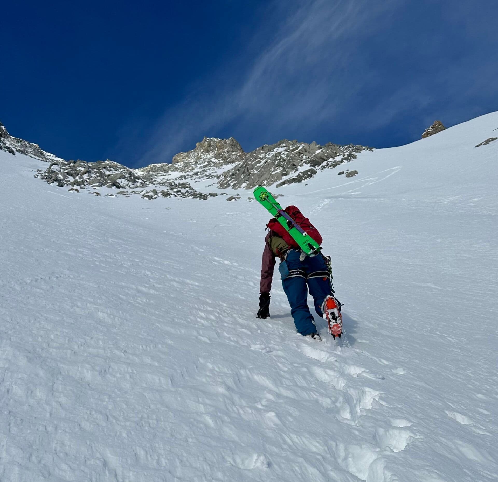 Skier climbs to the top of a mountain 