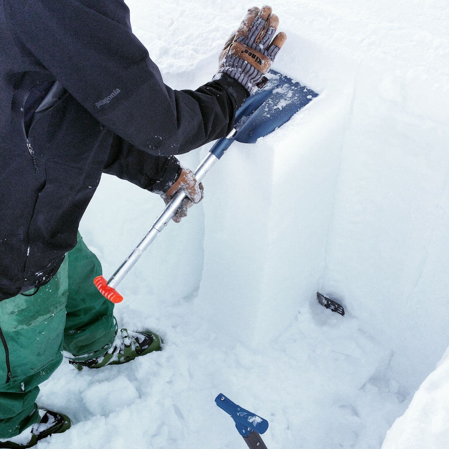 Person packing down snow in avalanche course 