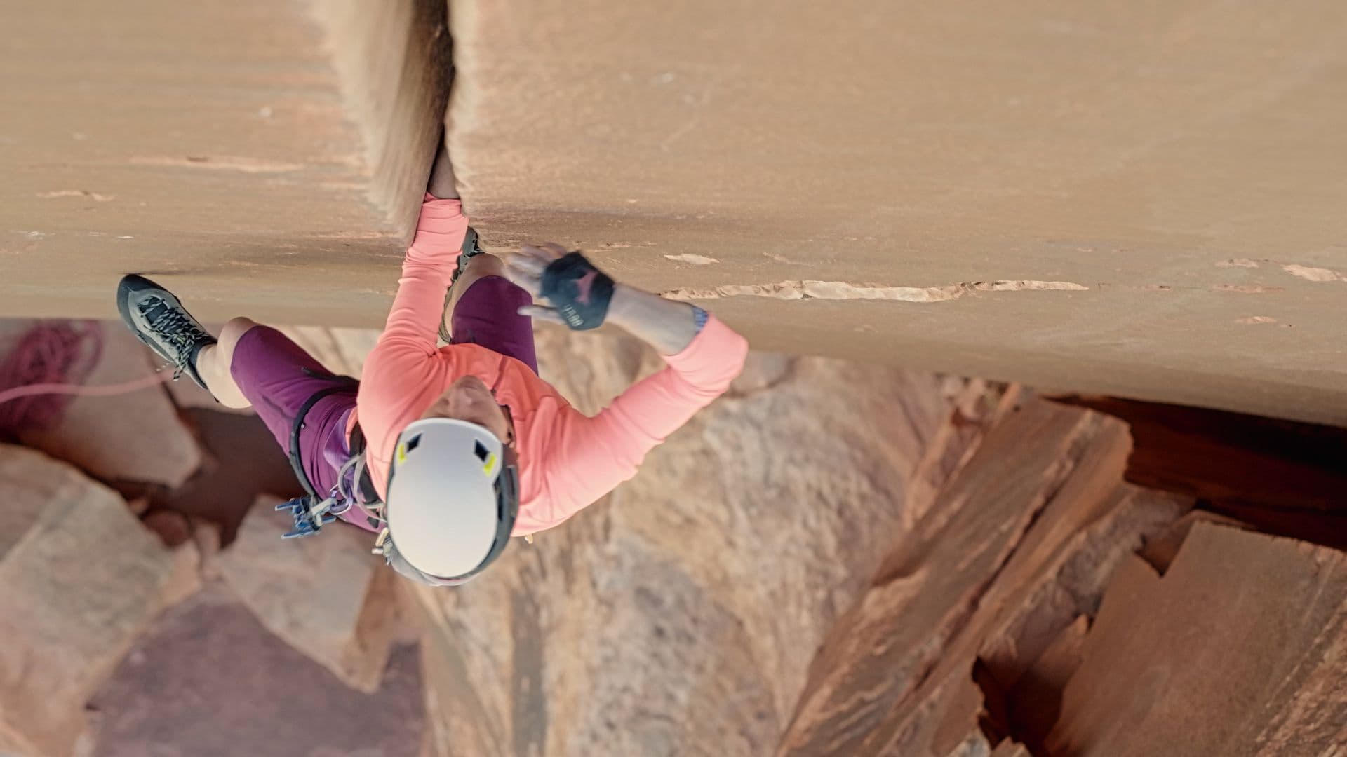 Woman carefully climbing a canyon 