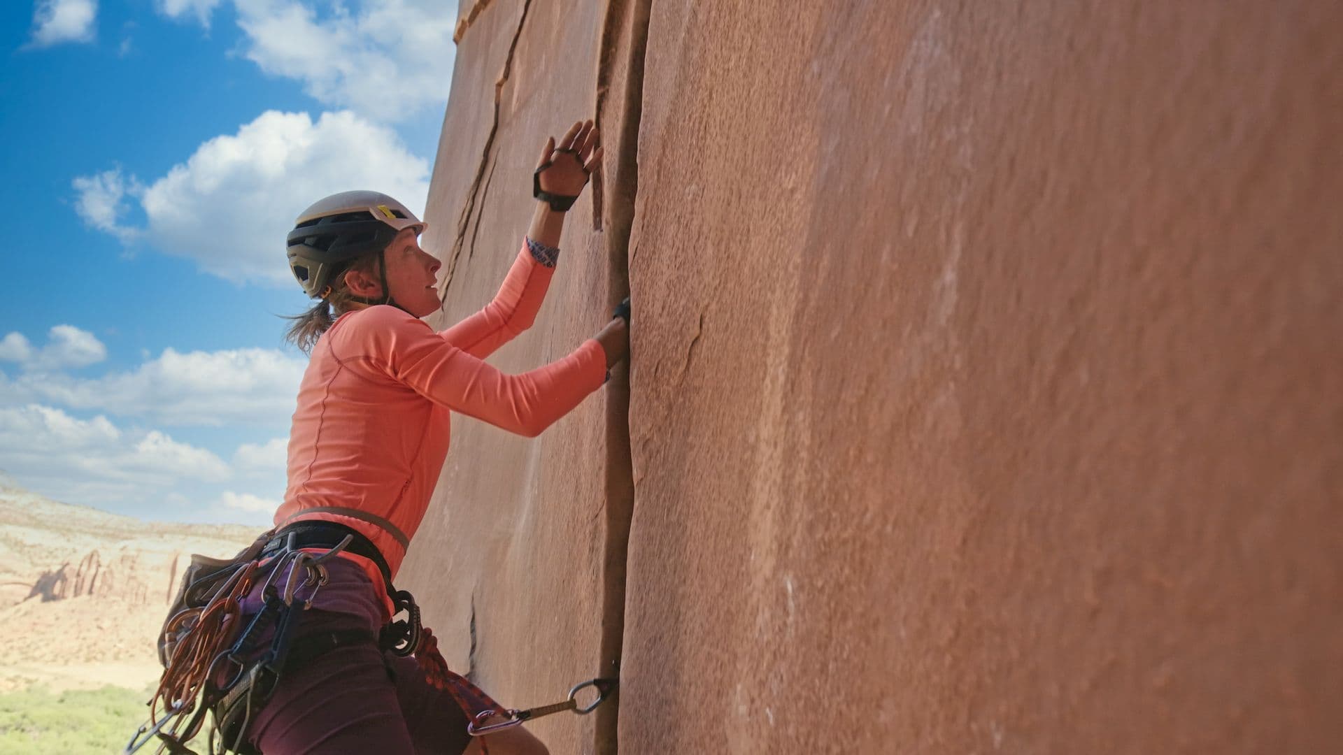 Woman climbing side of mountain in Moab