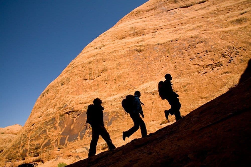 Three people hiking a canyon