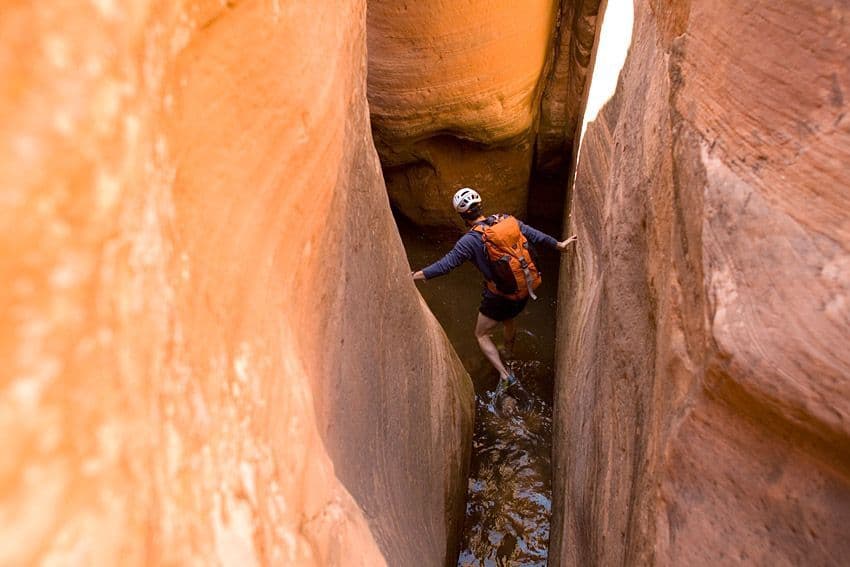 Person canyoneering into water 