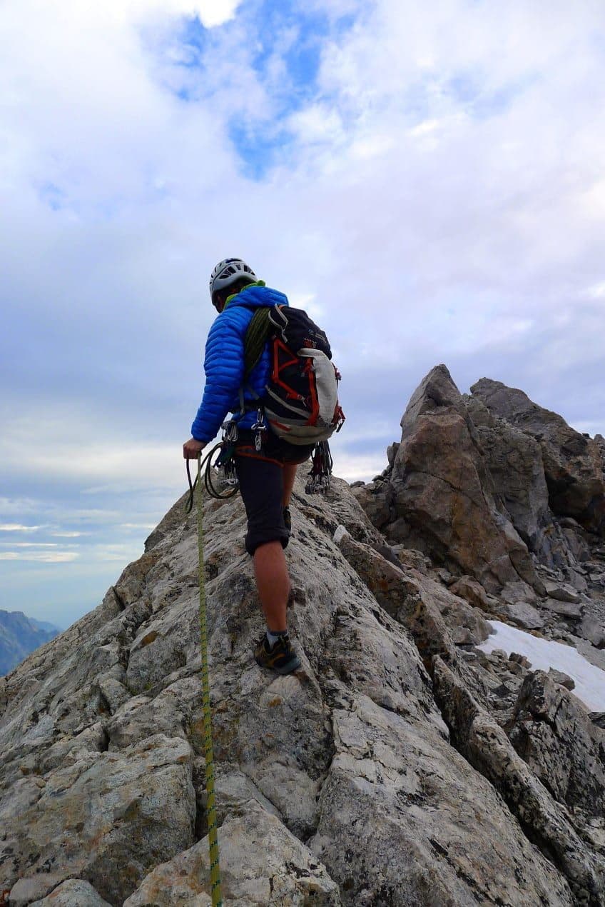 Climber reaching summit of mountain 