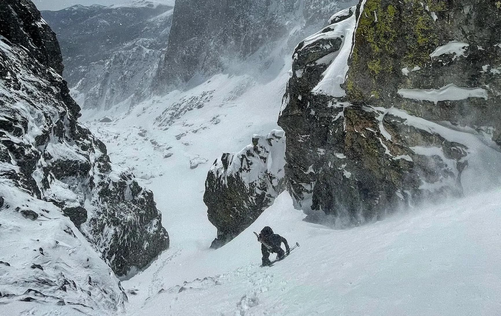 Person skiing down rocky mountains