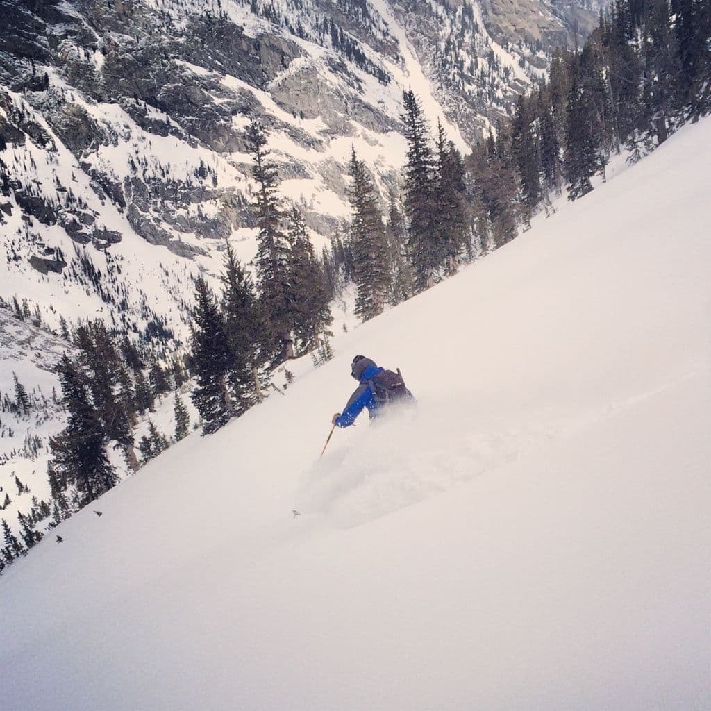 Skier going down deep powder