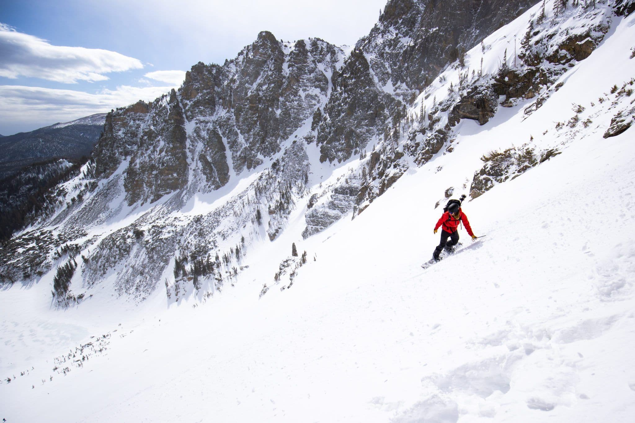 Skier navigating steep terrain of a mountain side 