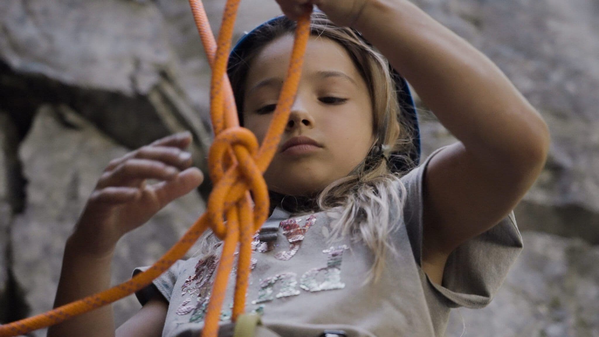 Girl tying rope to prepare for rock climbing