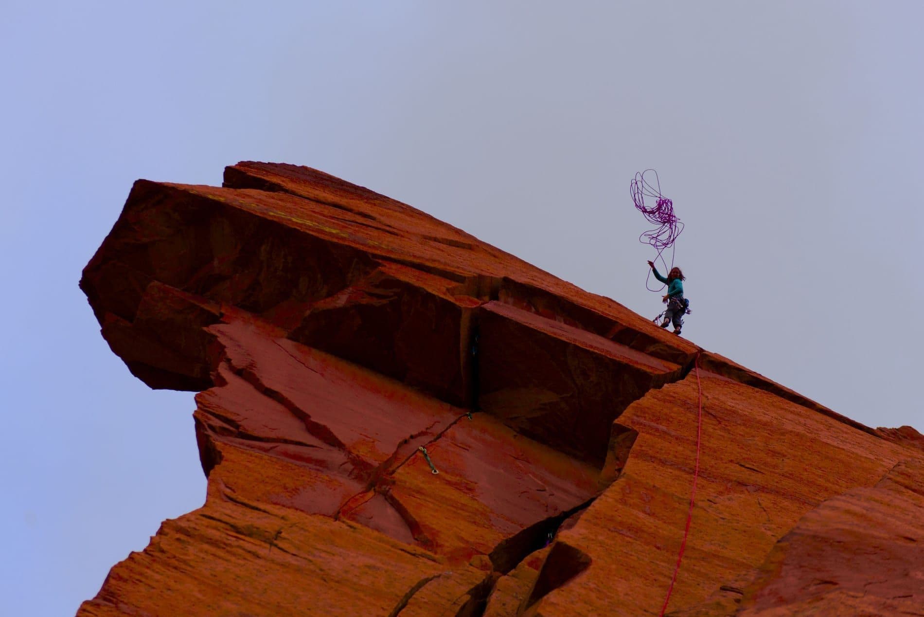 Woman throwing down rope to climb 