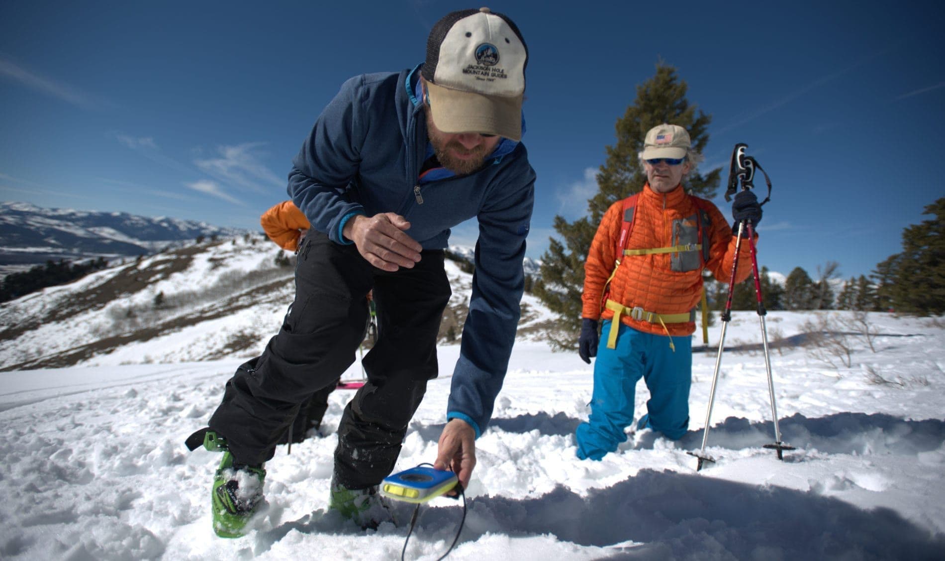 Instructor using measuring device in avalanche course