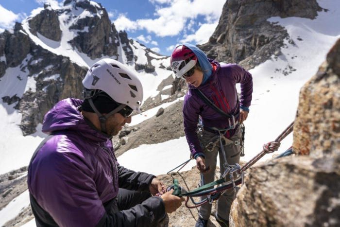 Instructor showing climbing equipment