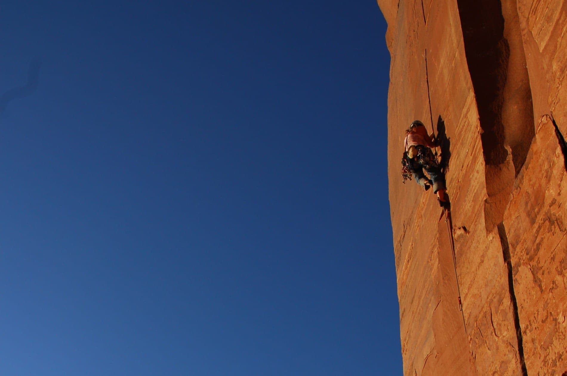 Person climbing side of canyon in moab utah