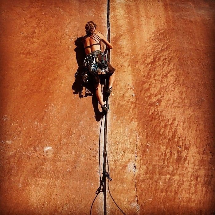 Woman climbing the side of a canyon