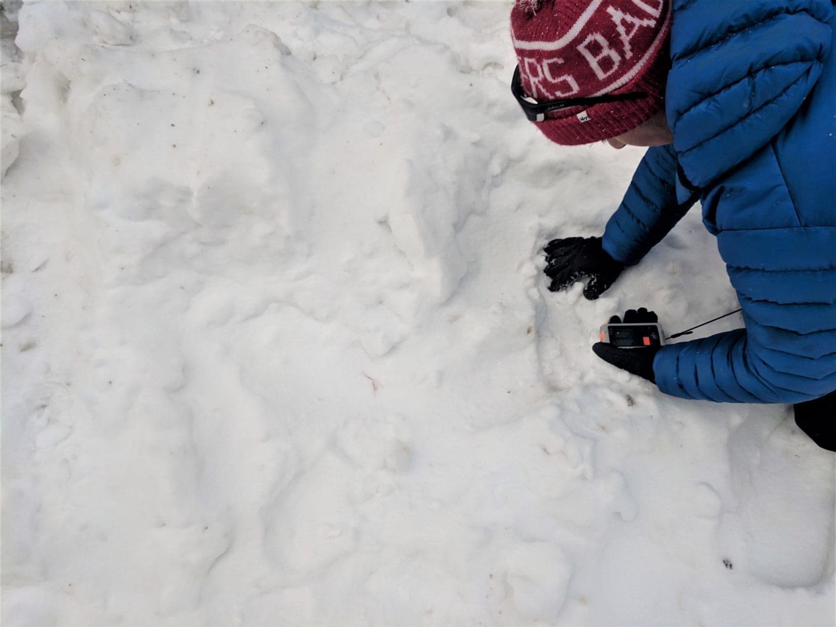 Person digging in snow in avalanche course