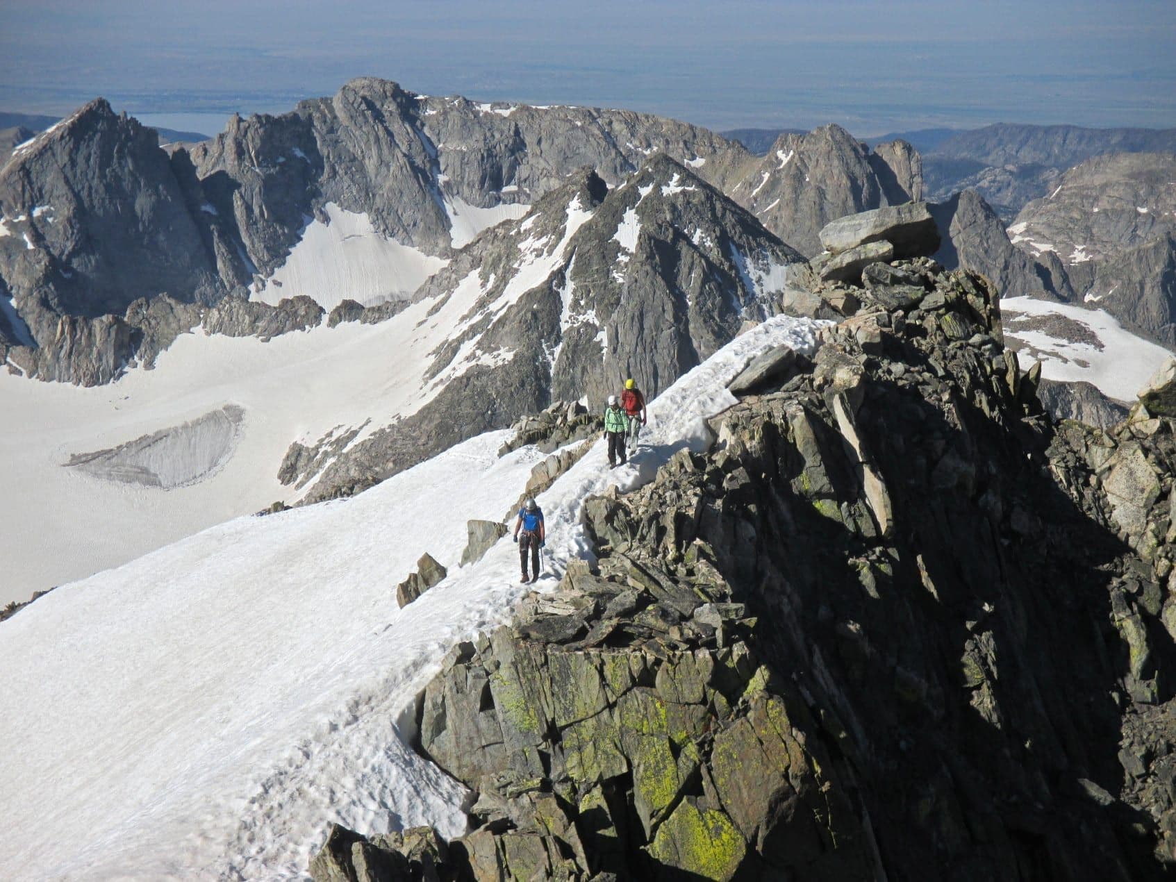 Hikers maneuvering snowy terrain at Gannett Peak