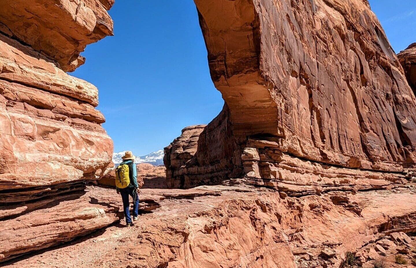 Person hiking through arch of a canyon in Moab