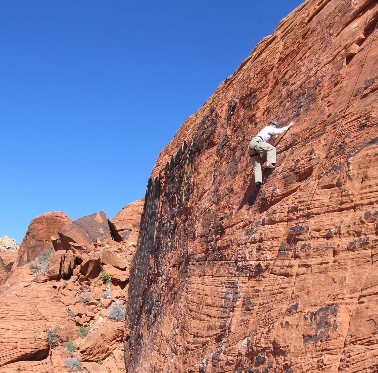 Person scaling the side of Red Rock