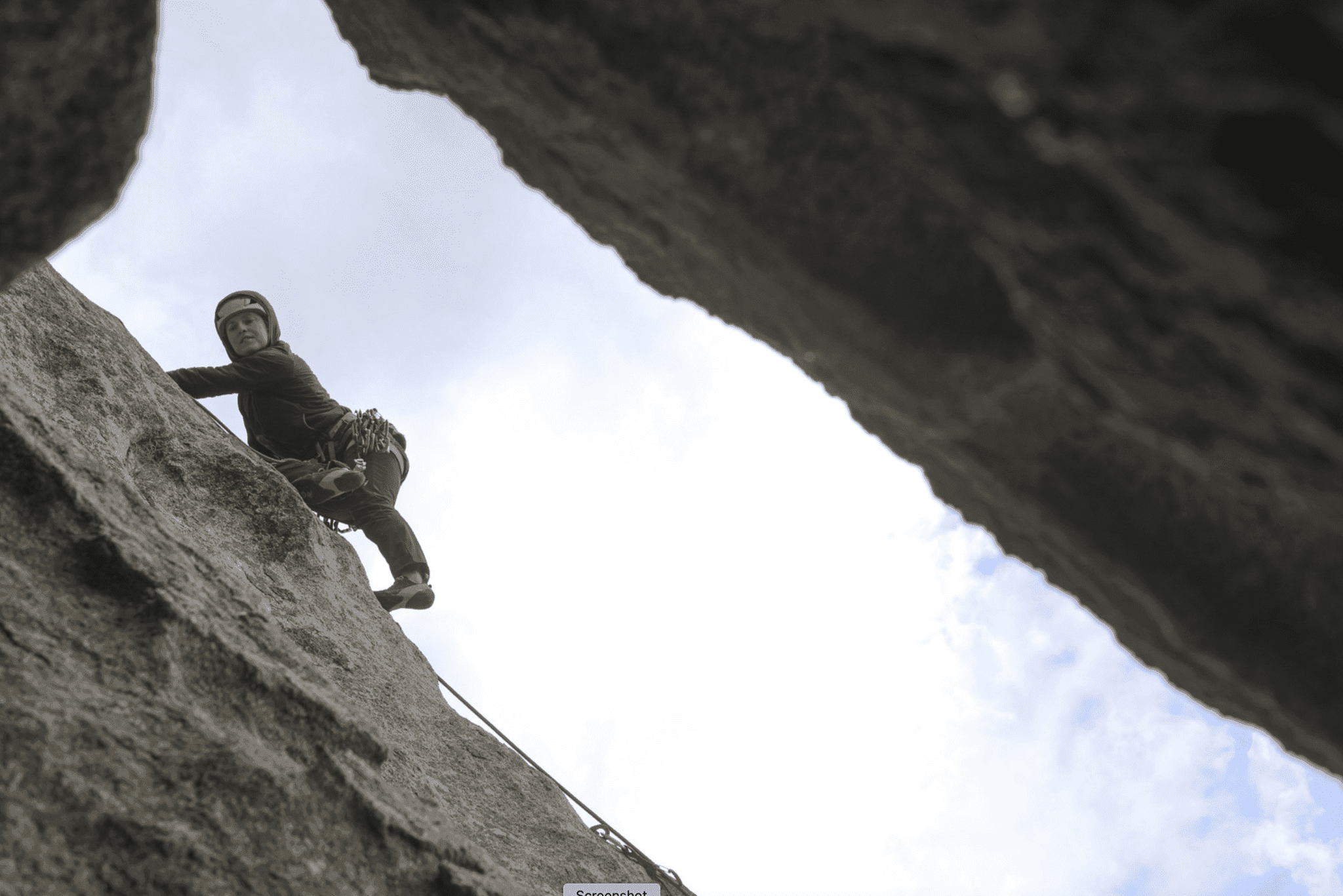 Woman climbing narrow passage in city of rocks