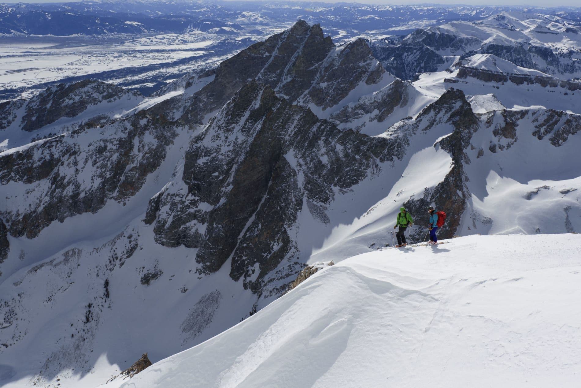Backcountry skiers on edge of mountain face