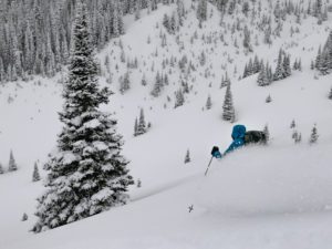 a skier taking deep turns in the mountains