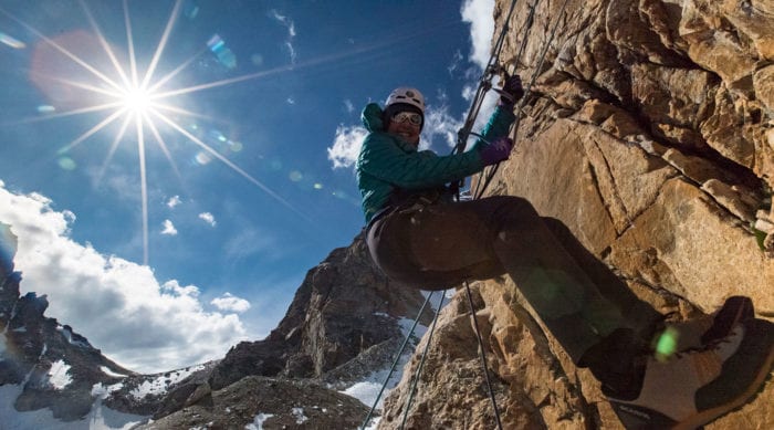 Rock climber rappels off the Grand Teton on a sunny day.