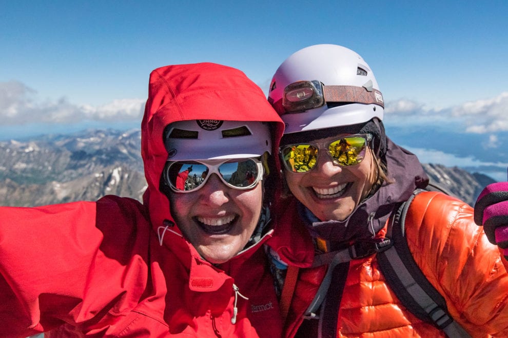 Two women celebrate summiting the Grand Teton in Grand Teton National Park.