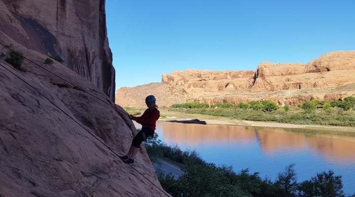 a climber repelling near a river
