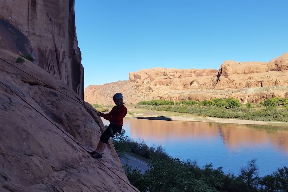 a climber repelling near a river