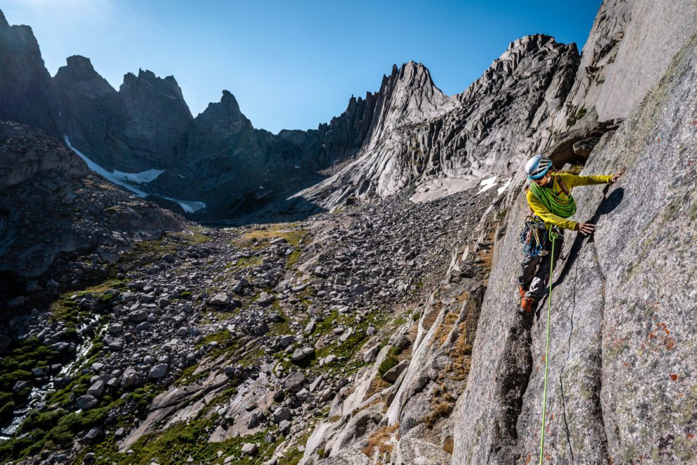 Rock climber traverses a s slab in the Cirque of the Towers in the Wind River Mountain Range.