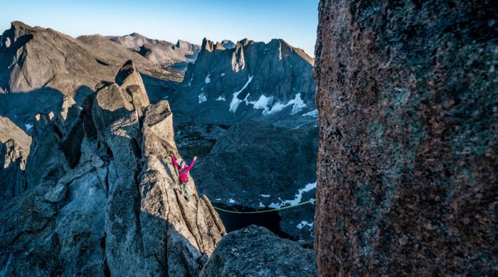 Rock climber celebrates while climbing Wolf's Head in the Wind River Range.