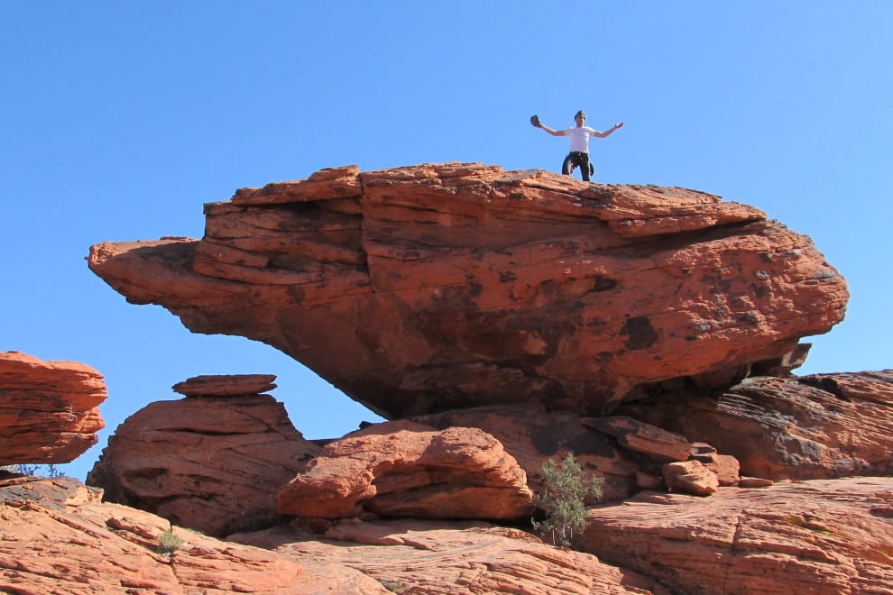 a climber summits a large boulder