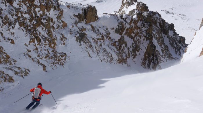 a skier dropping into a couloir in the tetons