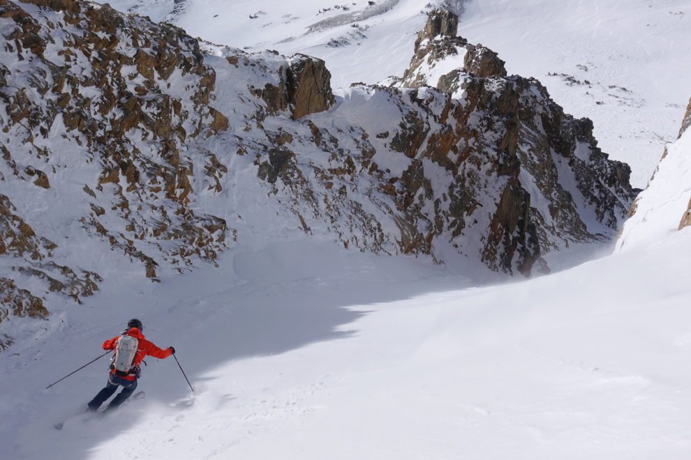 a skier dropping into a couloir in the tetons