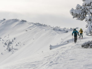 two skiers traversing across a ridge