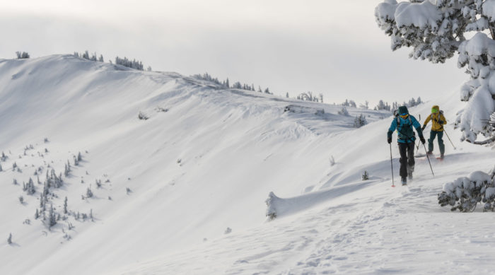 two skiers traversing across a ridge