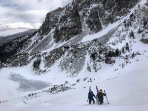 Two ski mountainers bootpack up a slope in Rocky Mountain National Park.