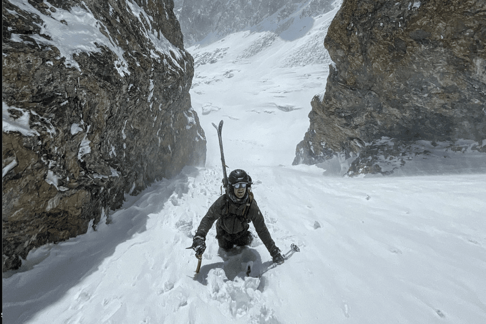 Ski mountaineer bootpacks up a couloir.