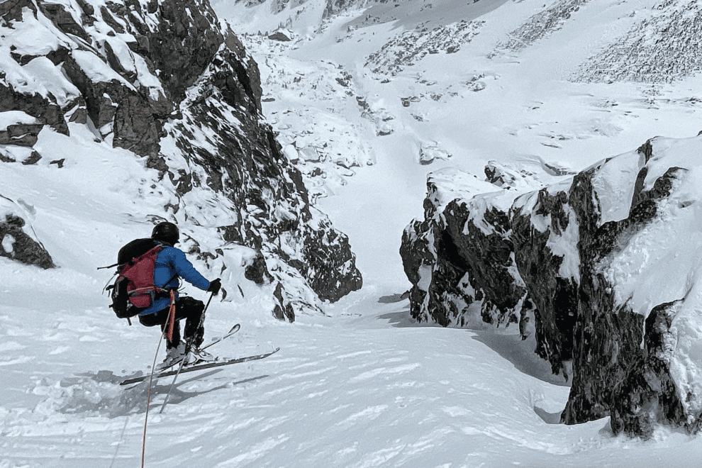 Ski mountaineer descends down a couloir.