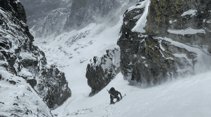 Ski mountainner ascends up a couloir.