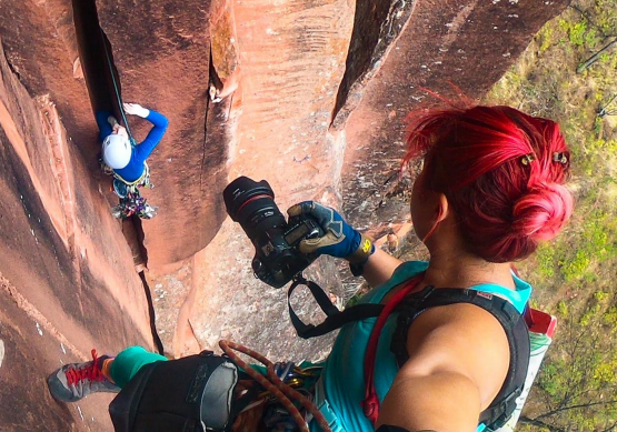 photographing rock climber in red rock